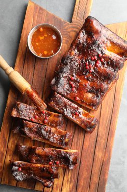 Lezzetli kaburgalar, sos ve fırça gri masada, üst manzara