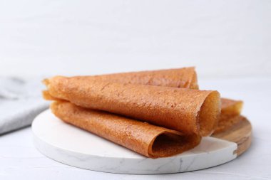 Lezzetli meyve dürümleri beyaz masada, yakın plan.