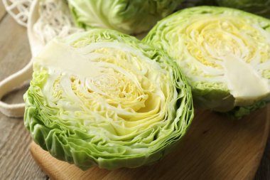 Taze lahanalar ve ahşap masada ağ torba, yakın plan.