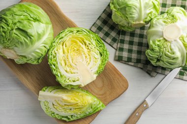 Taze taze lahana ve açık ahşap masa üzerinde kesilmiş lahanalar.