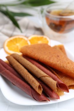 Lezzetli meyve dürümleri beyaz masada, yakın plan.