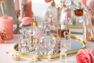 İçerideki tuvalet masasında farklı parfüm ve aksesuar şişeleri, yakın plan.