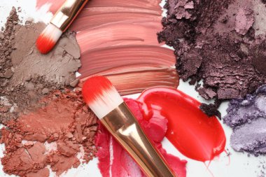 Beyaz arka planda farklı kozmetik ürünler ve makyaj fırçaları, düz yatış