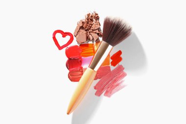 Beyaz arka planda farklı kozmetik ürünleri ve makyaj fırçası, düz konum