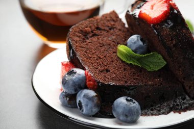 Çilekli, nane ve böğürtlenli lezzetli çikolatalı kek parçaları, yakın plan.