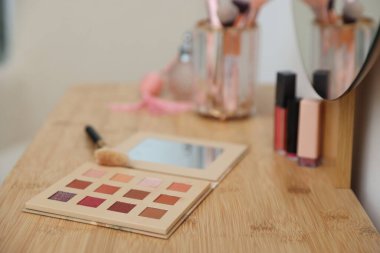 İçerideki ahşap tuvalet masasında fırçalı göz falı, yakın plan. Kozmetik ürünleri