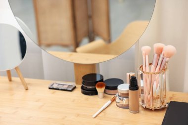 Farklı makyaj ürünleri ve kapalı mekandaki gösteriş fırçaları, yakın çekim