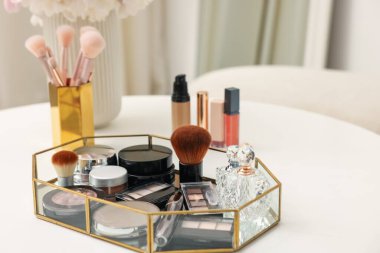 Beyaz masadaki farklı makyaj ürünlerinin olduğu tepsi kapalı, yakın çekim