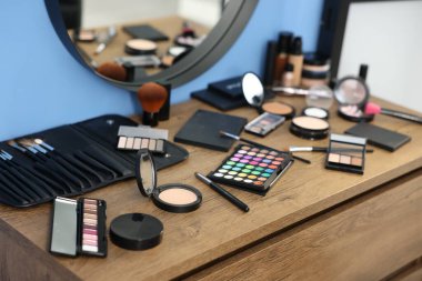 Farklı makyaj ürünleri ve kapalı mekandaki gösteriş fırçaları, yakın çekim