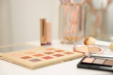 Beyaz masada farklı makyaj ürünleri, kapalı masa, yakın çekim.