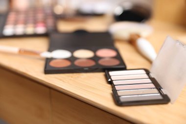 Kapalı alanda ahşap gösteriş üzerine farklı makyaj ürünleri.