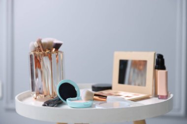 Beyaz masada farklı makyaj ürünleri, kapalı masa, yakın çekim.