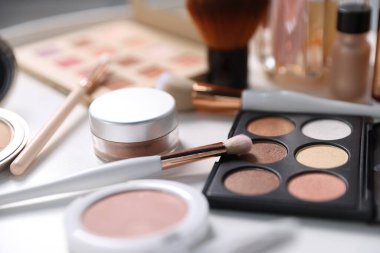 Beyaz masada farklı makyaj ürünleri, yakın plan.