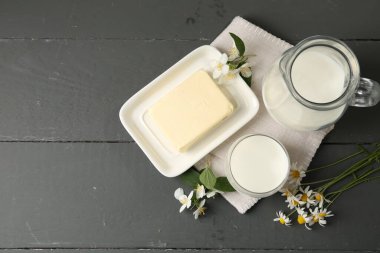 Taze süt ürünleri ve çiçekler gri ahşap masada, düz yerde. Metin için boşluk