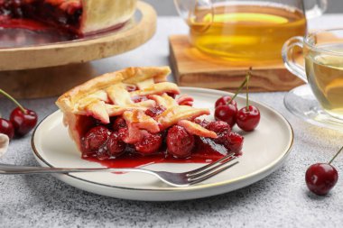 Lezzetli vişneli turta, böğürtlen ve çatal gri desenli masa, yakın plan.