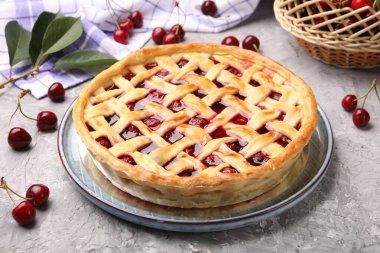 Gri desenli masada vişneli turta ve böğürtlen. Yakın plan.