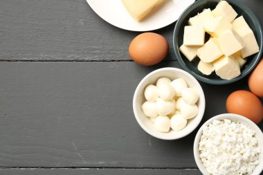 Gri ahşap masa üzerinde farklı süt ürünleri ve yumurtalar, düz yatak. Metin için boşluk