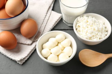 Gri ahşap masada farklı süt ürünleri ve yumurtalar, yakın plan.