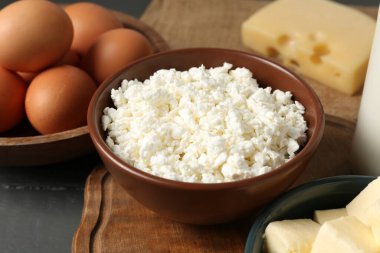 Gri ahşap masada farklı süt ürünleri ve yumurtalar, yakın plan.