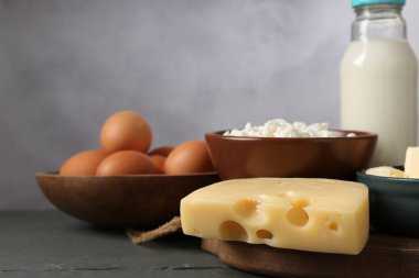 Gri ahşap masada farklı süt ürünleri ve yumurtalar, yakın plan.