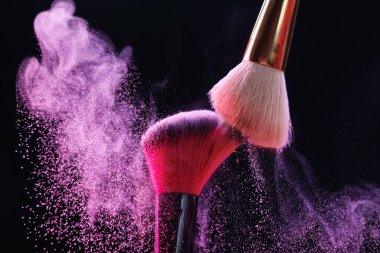 Siyah arkaplanda renkli göz gölgeli makyaj fırçaları, yakın plan