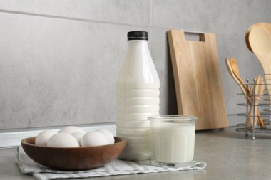 Mutfaktaki gri desenli masada süt ürünleri ve yumurtalar.