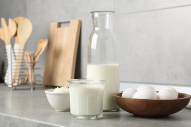 Mutfaktaki gri desenli masada farklı süt ürünleri ve yumurtalar.