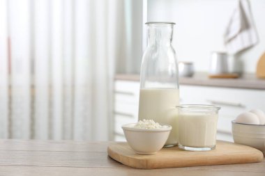 Mutfaktaki ahşap masada farklı süt ürünleri ve yumurtalar.