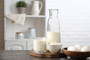 Mutfaktaki gri desenli masada farklı süt ürünleri ve yumurtalar.