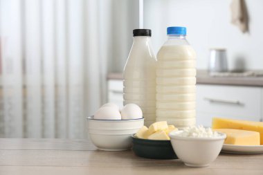 Mutfaktaki ahşap masada farklı süt ürünleri ve yumurtalar.