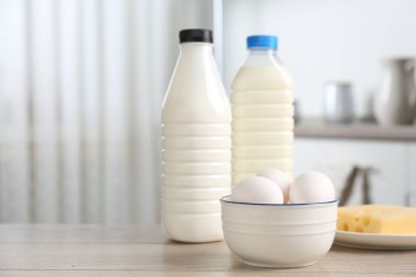 Mutfaktaki ahşap masada farklı süt ürünleri ve yumurtalar. Metin için boşluk