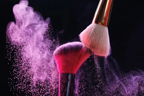 Siyah arkaplanda renkli göz gölgeli makyaj fırçaları, yakın plan
