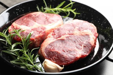 Yemek masasında çiğ et ve baharat parçaları, yakın plan.