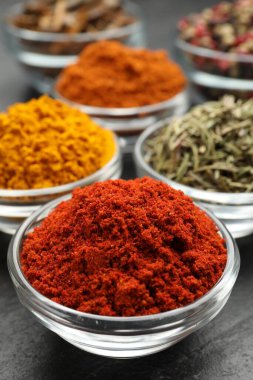 Gri masada farklı aromatik baharatlar, yakın plan.