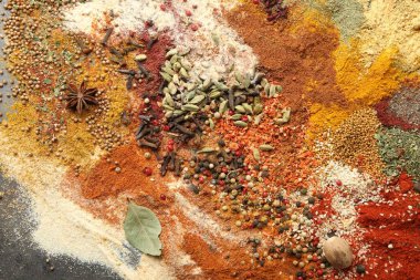 Gri masada farklı aromatik baharatlar, üst görünüm.