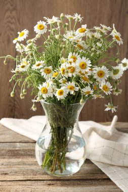 Tahta masadaki cam vazoda güzel papatya çiçekleri.