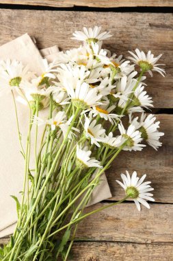 Tahta masanın üzerinde bir sürü güzel papatya çiçeği vardı.