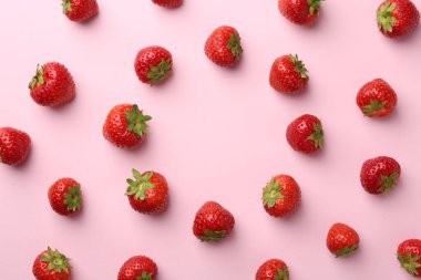 Açık pembe arka planda taze olgun çilek çerçevesi, düz. Metin için boşluk