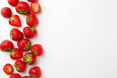 Beyaz arka planda taze olgun çilekler, düz uzanmış. Metin için boşluk