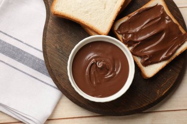 Lezzetli çikolatalı tereyağı ve ekmek dilimleri açık ahşap masa, üst manzara.