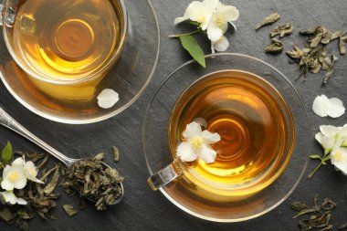 Aromatik yasemin çayı, bira ve çiçekler gri masada, düz uzanmış