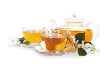 Camdan fincanlar, çaydanlık, çiçekler ve beyaz üzerine izole edilmiş yeşil yapraklar.