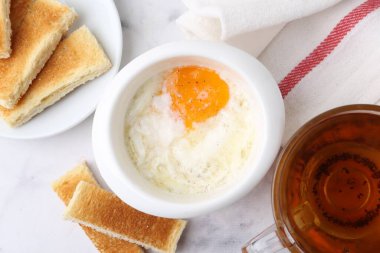 Yarı haşlanmış yumurta, çay ve kızarmış ekmek beyaz mermer masada, düz yerde. Geleneksel Asya kahvaltısı