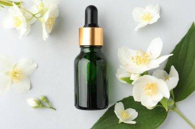 Kozmetik ürünleri ve yasemin çiçekleri arka planda, düz yatıyordu