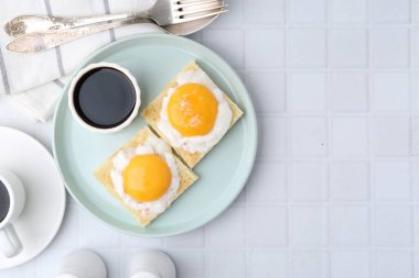 Lezzetli kaya tostlarıyla geleneksel Asya kahvaltısı ve kaynamış yumurtalar beyaz fayanslı masada servis ediliyor. Metin için boşluk