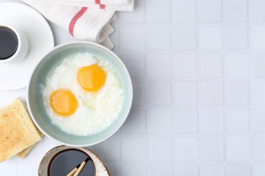 Geleneksel Asya kahvaltısı, yarı haşlanmış yumurta, soya sosu, tost ve kahve, beyaz fayanslı masa, düz yatak. Metin için boşluk
