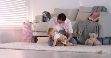 Anne ve küçük bebeği evde oyuncak ayıyla oynuyorlar, seçici bir odaklanma.