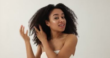 Güzel Brezilyalı kadın açık arkaplandaki spa tedavisinden sonra saçını düzeltiyor.