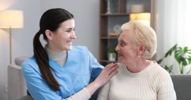 Hemşire, kanepede son sınıf öğrencisine yardımcı oluyor. Ev sağlık hizmetleri