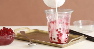 Beyaz masada lezzetli sütlü çay yapan kadın, yakın plan.